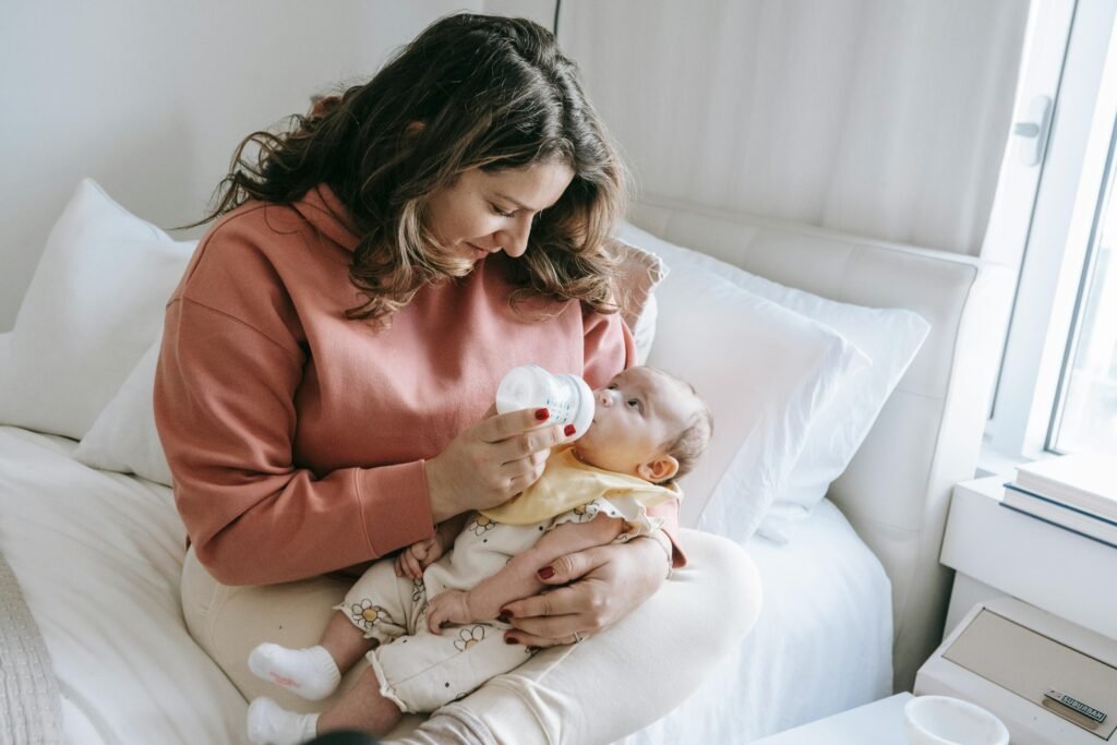 Parent feeding newborn baby at home